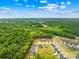 Scenic aerial view showcases neighborhood surrounded by lush greenery under a clear blue sky, showcasing its location at 2012 Slippery Rock Ln, Monroe, NC 28112