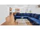 Open-concept living room featuring a plush blue sofa and coffee table, seamlessly connected to a modern kitchen at 2012 Slippery Rock Ln, Monroe, NC 28112