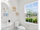 Well-lit powder room featuring a sleek sink, toilet, window, and stylish decor creating a welcoming space at 2012 Slippery Rock Ln, Monroe, NC 28112