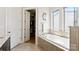 A bathroom featuring a soaking tub, walk-in closet, and lots of natural light at 2518 Marshall Pl, Charlotte, NC 28203