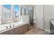 Bright bathroom featuring a soaking tub and a glass-enclosed shower with neutral tiling at 2518 Marshall Pl, Charlotte, NC 28203