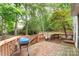 View of the wooden back deck with built-in hot tub and grill overlooking the trees at 2608 Yarrow Rd, Charlotte, NC 28213