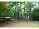 View of the home's backyard with mature trees, a hot tub on a deck, and a picnic table at 2608 Yarrow Rd, Charlotte, NC 28213