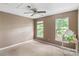 Comfortable bedroom with a ceiling fan and ample natural light streaming through two windows at 2608 Yarrow Rd, Charlotte, NC 28213