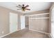 Bedroom with ceiling fan, built-in shelving, and neutral walls that let in natural light at 2608 Yarrow Rd, Charlotte, NC 28213