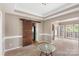 Dining room featuring a sliding barn door and neutral walls, complemented by crown molding and plush carpeting at 2608 Yarrow Rd, Charlotte, NC 28213