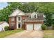 Beautiful brick home with two-car garage and well-maintained landscaping, including a large front lawn and mature trees at 2608 Yarrow Rd, Charlotte, NC 28213