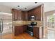 Well-equipped kitchen with dark wood cabinets, stainless steel appliances, and granite countertops at 2608 Yarrow Rd, Charlotte, NC 28213