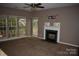 Cozy living room with a fireplace and mantle, enhanced by natural light from large windows at 2608 Yarrow Rd, Charlotte, NC 28213