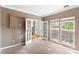 Bright living room with neutral carpet and trim, showcasing views of the backyard and front door, creating a welcoming space at 2608 Yarrow Rd, Charlotte, NC 28213