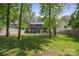 Expansive backyard with mature trees, a well-maintained lawn, and a partial view of the house at 2637 Springway Dr, Charlotte, NC 28205