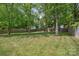 Lush backyard framed by mature trees and a wooden fence, offering privacy and shade at 2637 Springway Dr, Charlotte, NC 28205