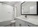 Bright bathroom with a tub, white tiled walls and floors, a large mirror, and a black shower head and tap at 2637 Springway Dr, Charlotte, NC 28205