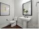Modern half-bathroom with a pedestal sink, sleek black fixtures, and stylish decor at 2637 Springway Dr, Charlotte, NC 28205
