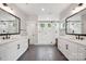 Spacious bathroom with dual vanities, a glass-enclosed shower, dark tiled floors and white fixtures at 2637 Springway Dr, Charlotte, NC 28205