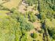 Picturesque aerial view highlighting the property's mature trees, fields, and serene pond at 290 Glenmere Ln, Mooresville, NC 28115