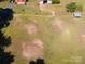 Aerial view of mostly level grassy land with multiple storage buildings and mature trees at 290 Glenmere Ln, Mooresville, NC 28115