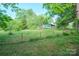 Green grassy yard with the home in the distance, and surrounded by a chain-link fence at 290 Glenmere Ln, Mooresville, NC 28115