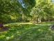 Expansive backyard featuring mature trees and well-manicured lawn, ideal for outdoor activities at 3068 Streamhaven Dr, Lancaster, SC 29707