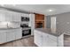 Modern kitchen features white cabinets, stainless steel appliances, granite countertops, and brick fireplace at 332 E Rebound Rd, Lancaster, SC 29720