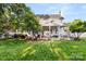 Charming backyard featuring a covered patio, lush lawn, mature trees, and a pristine white fence at 3340 Blue Jay Pass, Fort Mill, SC 29708