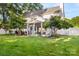 Expansive backyard showcasing a covered patio, green grass, well-placed trees, and a white picket fence at 3340 Blue Jay Pass, Fort Mill, SC 29708