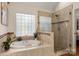 Bright bathroom featuring a soaking tub, glass-enclosed shower, and natural light from the window at 3340 Blue Jay Pass, Fort Mill, SC 29708