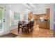 Dining area with hardwood floors, wooden table, and a view into the modern kitchen at 3340 Blue Jay Pass, Fort Mill, SC 29708