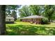 View of the backyard with green grass, a brick home with blue shutters, and a matching storage shed at 3418 Sulphur Springs Ne Rd, Hickory, NC 28601