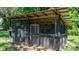 Close up view of the dark wood chicken coop featuring a metal roof, wire caging, and a hinged door at 3418 Sulphur Springs Ne Rd, Hickory, NC 28601