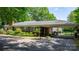 Side view of the red brick home, featuring a covered carport, an iron railing, and blue shutters at 3418 Sulphur Springs Ne Rd, Hickory, NC 28601