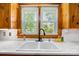 Kitchen sink with gooseneck faucet and white countertops are brightly lit by a large window and white subway tile at 3418 Sulphur Springs Ne Rd, Hickory, NC 28601
