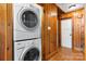 Laundry area features a stackable washer and dryer in a room with wood paneling and decorative floor at 3418 Sulphur Springs Ne Rd, Hickory, NC 28601