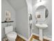 Half bathroom featuring a pedestal sink, round mirror, and hardwood floors at 3426 Richards Xing, Fort Mill, SC 29708