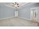 Open bedroom with neutral carpet, soft gray walls, a ceiling fan, and a tray ceiling at 3426 Richards Xing, Fort Mill, SC 29708