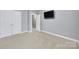 Spacious bedroom featuring neutral carpet, soft gray walls, and a wall-mounted TV for comfortable viewing at 3426 Richards Xing, Fort Mill, SC 29708