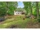 Spacious backyard with a view of the two-story home and surrounding trees at 3690 Birchwood Ln, Denver, NC 28037