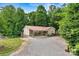 Charming tan home with a red roof and a covered front porch surrounded by lush greenery at 3690 Birchwood Ln, Denver, NC 28037