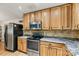 Galley kitchen featuring natural wood cabinets, stainless steel appliances, and speckled granite countertops at 3690 Birchwood Ln, Denver, NC 28037