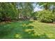 Lush green backyard with mature trees and a charming wooden fence at 3918 Rea Rd, Charlotte, NC 28226