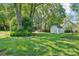Spacious backyard with a storage shed, lush green lawn, and mature trees offering ample shade at 3918 Rea Rd, Charlotte, NC 28226