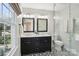 Modern bathroom with dual sinks, black and white patterned tile, and a glass-enclosed shower for spa-like experience at 3918 Rea Rd, Charlotte, NC 28226