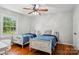 Bright bedroom features hardwood floors, a ceiling fan, and two twin beds with blue blankets at 3918 Rea Rd, Charlotte, NC 28226