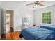 Bright bedroom includes hardwood floors, a ceiling fan, and a desk near the large window at 3918 Rea Rd, Charlotte, NC 28226