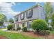 A charming two-story house showcasing a blend of brick and gray siding, set amidst lush greenery at 3918 Rea Rd, Charlotte, NC 28226