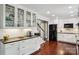 Kitchen area featuring white cabinets, glass door shelving, stainless steel appliances, and hardwood flooring at 3918 Rea Rd, Charlotte, NC 28226