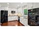 Modern kitchen with white cabinets, stainless steel appliances, hardwood floors, and under-cabinet lighting at 3918 Rea Rd, Charlotte, NC 28226