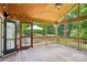 Inviting screened porch with wood flooring, string lights and wooded views at 3918 Rea Rd, Charlotte, NC 28226