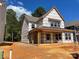 New construction two-story home featuring large windows, a covered porch with wooden beams, and spacious front yard at 4029 Grommet Ct, Matthews, NC 28105