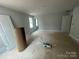 Spacious bedroom with three windows, neutral paint, and an adjacent door leading to another room at 4021 Grommet Ct # 4, Matthews, NC 28105